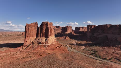 Aerial-view-of-Moab-rock-formations-with-passing-cars-along-the-road