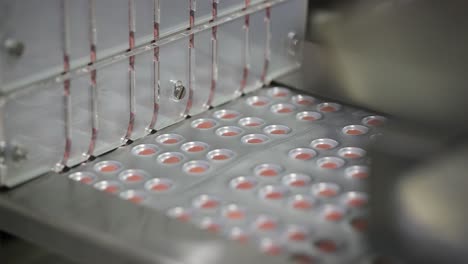 close-up-seen-Tablets-moving-from-inside-the-machine-to-the-packaging-line-are-visible