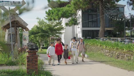 A-group-of-people-walks-along-a-charming-village-road