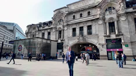 Tourists-and-commuters-are-walking-outside-the-entrance-to-Victoria-station-in-london,-england