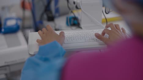 Vista-Más-Cercana-De-Escribir-En-El-Teclado-De-Un-Monitor-De-Salud-En-Un-Hospital-Francés