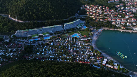 Aerial-view-rising-in-front-of-the-Rabac-resort,-sunset-in-Istria,-Croatia