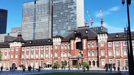 Commuters,-businessmen-and-salary-men-pass-by-the-historic-Marunouchi-side-of-Tokyo-Station,-the-central-hub-of-the-shinkansen-high-speed-rail-network-in-Japan-and-JR-East-commuter-metro-lines