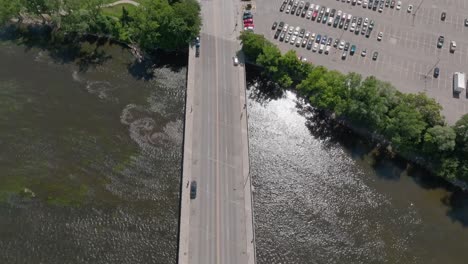 Overhead-view-of-bridge-and-Grand-River-in-Grand-Rapids,-Michigan-with-video-pulling-up-to-Grand-Rapids,-Michigan-skyline