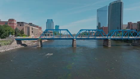 Blue-bridge-over-Grand-River-in-downtown-Grand-Rapids,-Michigan-with-drone-video-moving-left-to-right