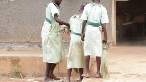 Tres-Niños-Barriendo-En-Una-Escuela-En-Uganda,-África