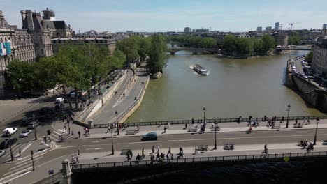 Boat-navigating-along-La-Seine-in-Paris,-Drone-view