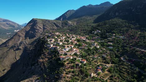 Panoramadorf-An-Der-Albanischen-Küste,-Auf-Einem-Felsigen-Hügel-Mit-Berghintergrund-Gelegen,-Ein-Balkon-Mit-Blick-Auf-Das-Ionische-Meer