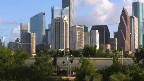 Establishing-drone-shot-of-downtown-Houston,-Texas-with-train-foreground