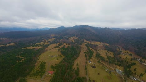 Drone-aerial-view-of-wonderful-nature-landscape-with-green-forests-and-mountain-background-on-a-cloudy-day-in-Colibita-area,-Transilvania,-Romania
