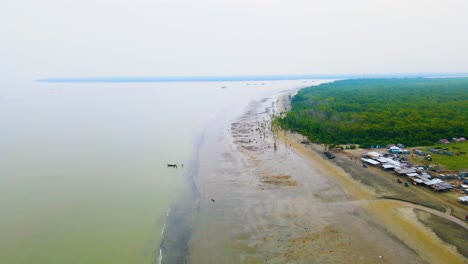 A-Bustling-Fish-Market-Thrives-Next-to-a-Small-Bazaar-At-Kuakata-Sea-Beach,-Near-the-Coast-of-the-Sundarban-Forest-in-Bangladesh---Aerial-Drone-Shot