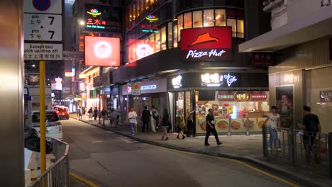 Belebte-Straße-In-Hongkong-Bei-Nacht-Mit-Neonschildern-Und-Passanten