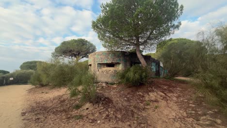 A-concrete-machine-gun-bunker,-a-relic-of-wartime-history,-stands-near-the-Spanish-coastline,-embodying-resilience-and-historical-significance-through-the-ages