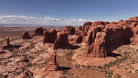 Drone-panorama-of-Moab-with-red-rock-formations-and-distant-desert-landscape-in-summer