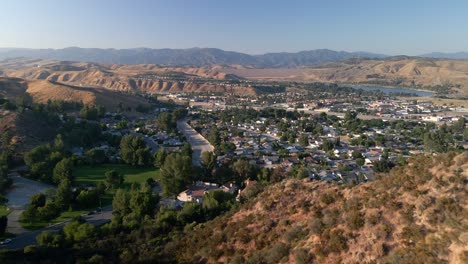 Drone-flying-over-hills,-revealing-a-residential-community-in-Santa-Clarita,-USA