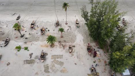 Fishermen-Mend-Their-Fishing-Nets-Next-to-Their-Boats-at-Kuakata-Sea-Beach-Along-the-Bangladesh-Coast---Aerial-Drone-Shot