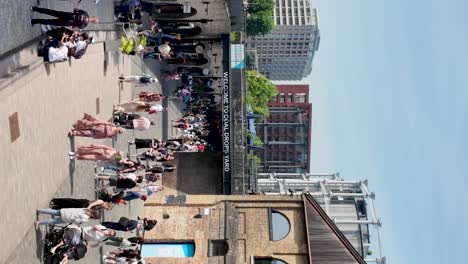 Bustling-scene-at-Kings-Cross,-London-with-people-exploring-Coal-Drops-Yard-on-a-sunny-day