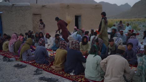 Hombres-Musulmanes-En-Khuzdar-Baluchistán-Esperando-Que-Se-Abra-El-Ayuno-En-El-Mes-De-Ramadán-Al-Aire-Libre-Con-Coloridos-Trajes-Tradicionales