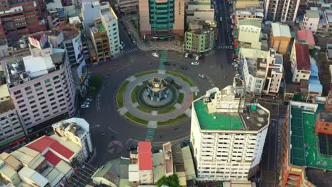 Aerial-birds-eye-view-drone-flyover-capturing-downtown-cityscape-featuring-Douliu-Circle,-the-landmark-roundabout-in-the-city-center,-Yunlin-county,-Taiwan