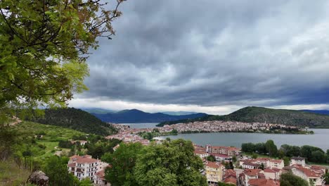 Mountain-lake-Orestiada-in-Kastoria-city-in-Greece,-cloudy-sky-in-spring