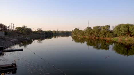 Ruhiger-Fluss-Mit-Grünem-Wald-Am-Ufer-Am-Morgen-Aus-Flachem-Winkel