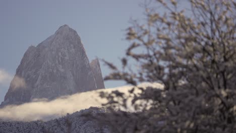 Timelapse-Místico-Del-Monte-Fitz-Roy-Con-Nubes-Moviéndose-En-Su-Base,-Visto-Desde-Detrás-De-Un-árbol-De-Nothofagus-En-La-Patagonia,-Argentina