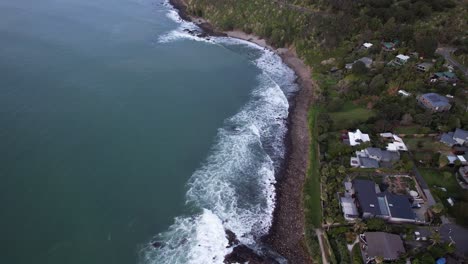 Olas-En-La-Costa-Rocosa-De-Whale-Bay,-Una-Casa-De-Vacaciones-Paradisíaca-Frente-A-La-Playa-En-Raglan,-Nueva-Zelanda