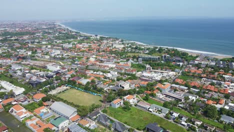 Aerial-view-of-Berawa,-Canggu,-Bali,-Indonesia-with-real-estate,-hotels,-villa,-beach-clubs-and-Bukit,-Uluwatu-at-the-background