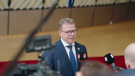 Finish-Prime-Minister-Petteri-Orpo-giving-a-statement-at-the-European-Council-summit-in-Brussels,-Belgium---Slow-motion,-medium-shot