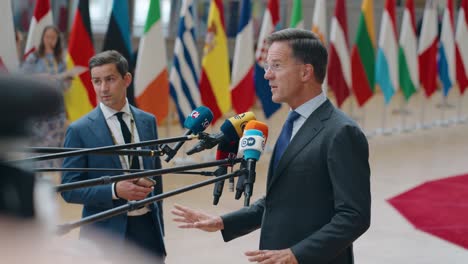 NATO-Secretary-General-Mark-Rutte-talking-to-the-press-at-the-European-Council-summit-in-Brussels,-Belgium---Side-view,-slow-motion