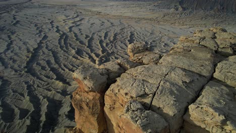 Vista-Aérea-De-Colinas-De-Arenisca-Secas-Y-Grises-Y-Sin-Vida-Y-Mesa-En-El-Desierto-De-Utah,-Paisaje-Lunar,-Disparo-De-Drones