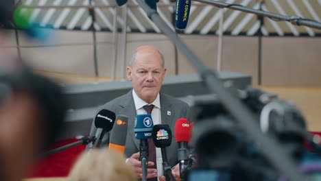Chancellor-of-Germany-Olaf-Scholz-talking-to-the-press-at-the-EU-summit-in-Brussels,-Belgium---Slow-motion,-medium-shot