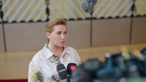 Danish-Prime-Minister-Mette-Frederiksen-talking-to-the-press-in-the-European-Council-building-during-EU-summit-in-Brussels,-Belgium---Medium-shot,-slow-motion