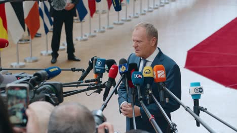 Polish-Prime-Minister-Donald-Tusk-talking-to-the-press-at-the-European-Council-summit-in-Brussels,-Belgium---Medium-shot