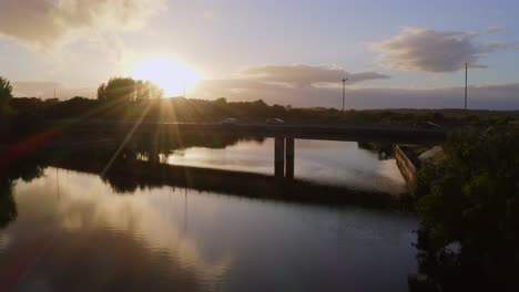 Static-aerial-establishing-view-of-Terryland-Forest-Park-and-Quincentennial-Bridge-crosses-River-Corrib-to-Galway-Ireland-at-sunset