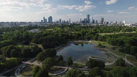 Estanque-Del-Parque-Y-Majestuoso-Horizonte-De-Varsovia,-Vista-Aérea-De-Drones