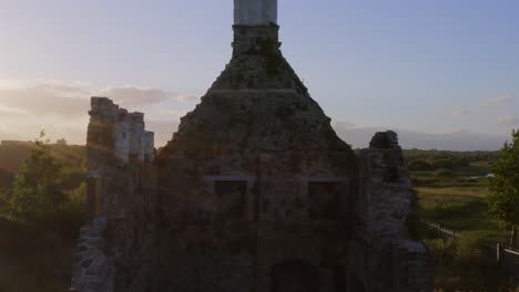 Terryland-Castle-along-River-Corrib-Galway-Ireland,-drone-ascends-from-grass-to-establish-old-ruins