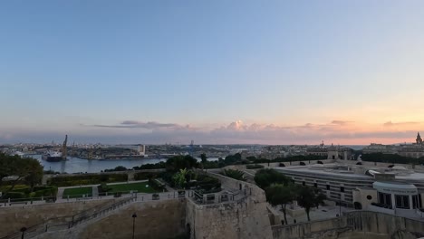 Panoramic-view-of-Valletta,-Malta,-during-dusk,-capturing-the-serene-beauty-and-urban-skyline-as-day-transitions-to-evening