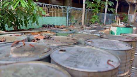 Pile-of-metal-barrels-containing-hazardous-chemical-waste-water-in-open-area