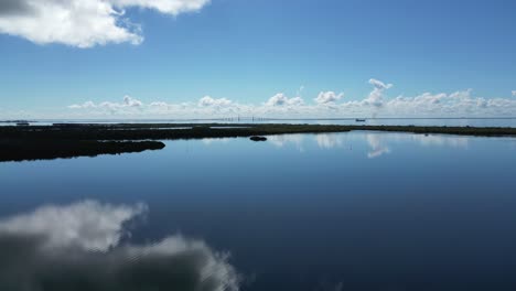 Rising-smoothly-over-glassy-calm-water-in-Florida-with-the-Skyway-bridge-in-the-distance-on-a-sunny-day
