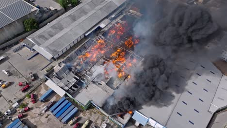 Top-orbit-shot-of-a-devastating-fire-in-a-warehouse-in-the-city-of-Santo-Domingo,-Dominican-Republic