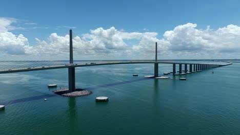 Drone-video-flying-toward-Sunshine-Skyway-Bridge-on-a-Sunny-Day-with-beautify-puffy-white-clouds-in-the-distance