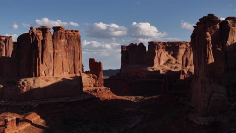 Majestic-red-rock-monoliths-tower-over-the-expansive-desert-terrain-of-Moab,-Utah,-USA