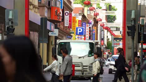 El-Barrio-Chino-De-Melbourne-En-Little-Bourke-Street-Es-Un-Centro-De-Actividad,-Con-Calles-Llenas-De-Tiendas-De-Souvenirs-Y-Restaurantes-Chinos,-Capturado-En-Cámara-Lenta-Mientras-La-Gente-Cruza-La-Calle.