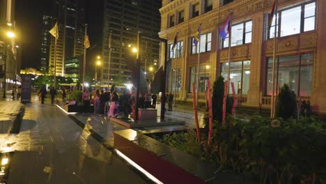 Vista-De-ángulo-Bajo-De-Chicago-Por-La-Noche-Después-De-La-Lluvia,-El-Pavimento-Mojado-Refleja-Las-Luces-De-Las-Farolas-De-Los-Edificios