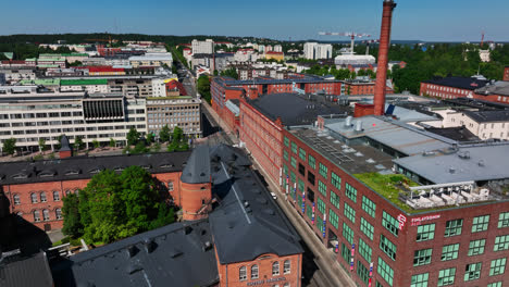 Vista-Aérea-Siguiendo-Las-Calles-Del-Distrito-Finlayson,-Verano-En-Tampere,-Finlandia