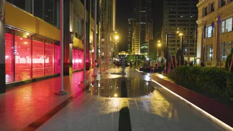 Low-Angle-Ansicht-Von-Chicago-In-Der-Nacht-Nach-Regenfällen,-Der-Nasse-Bürgersteig-Reflektiert-Das-Licht-Von-Gebäuden-Straßenlaternen