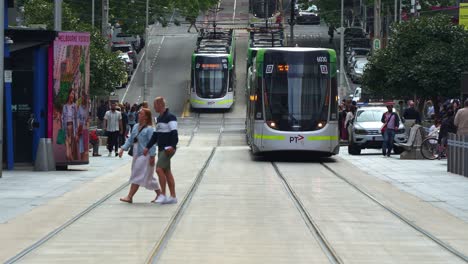 Straßenbahnen-Fahren-Entlang-Der-Bourke-Street,-Fußgänger-überqueren-Die-Straße-Und-Einkäufer-Schlendern-Auf-Den-Bürgersteigen-Der-Bourke-Street-Mall-Im-Zentralen-Geschäftsviertel-Von-Melbourne,-Einer-Lebendigen-Urbanen-Szene.