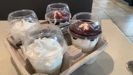 Four-soft-serve-ice-cream-sundaes-on-a-restaurant-table