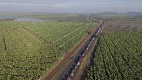 Filmische-Drohnenansicht-Einer-Großen-Anzahl-Von-Lastwagen,-Die-In-Einer-Langen-Schlange-Auf-Einer-Autobahn-Vor-Einem-Grenzposten-Feststecken